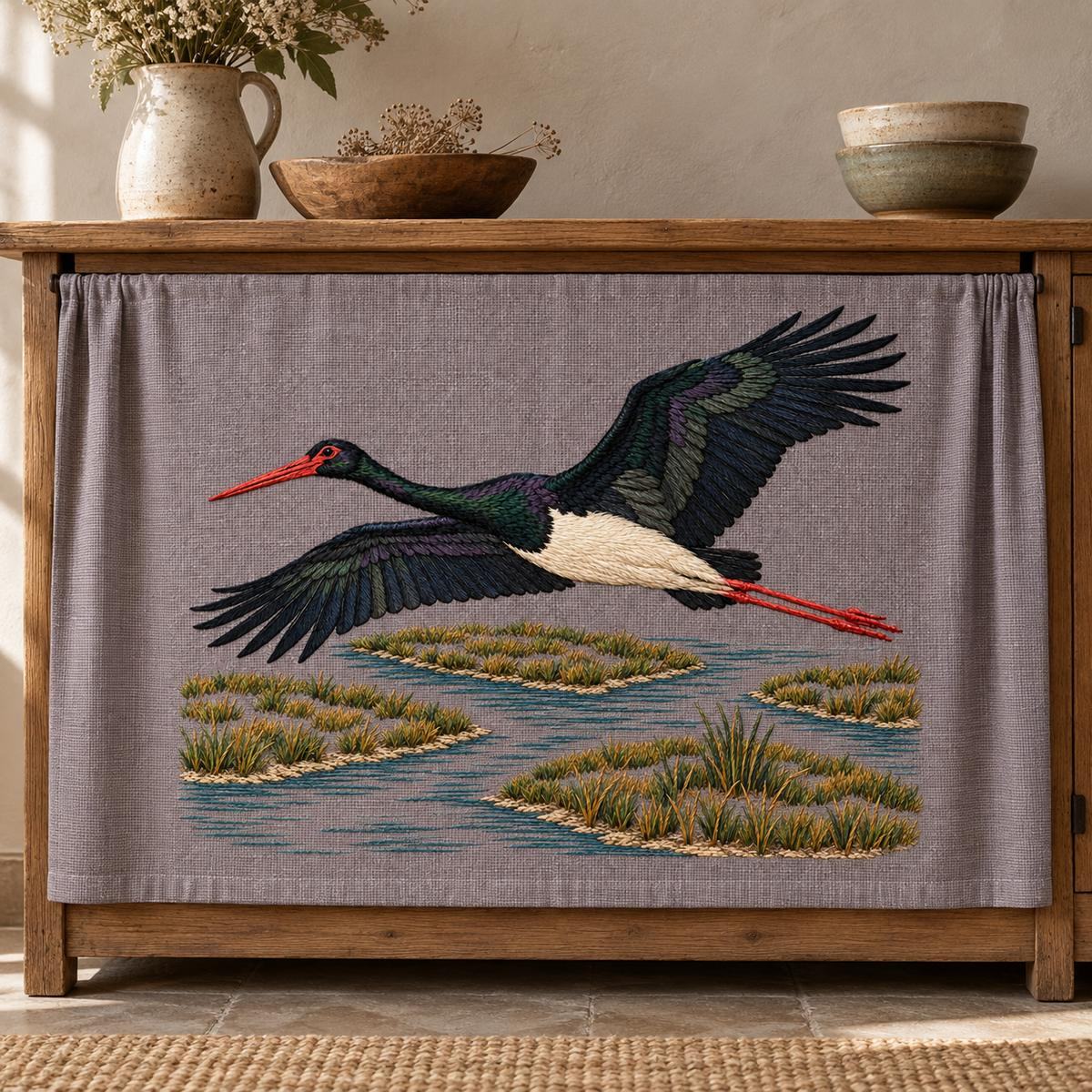 Black Stork embroidery design in a digital mockup of A plum-grey linen horizontal wall cabinet curtain on a wide seed cupboard, taut and flat with small edge pleats outside motif. Placement inspiration for Study 08.