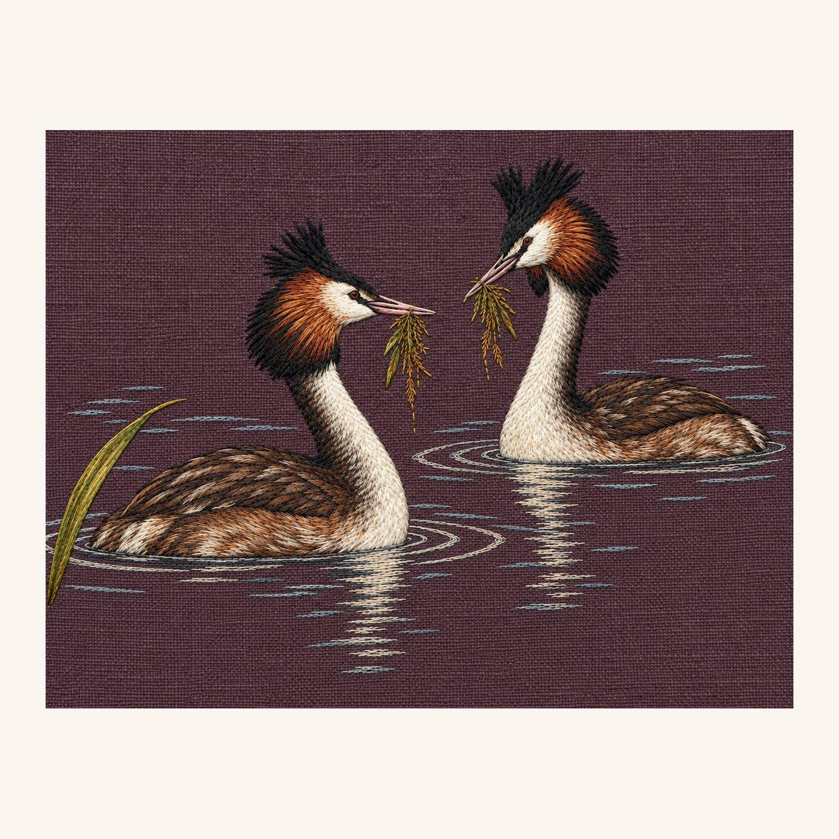 Digital embroidery reference showing a grebe pair holding separate weed tufts on deep smoky mulberry linen, landscape composition.