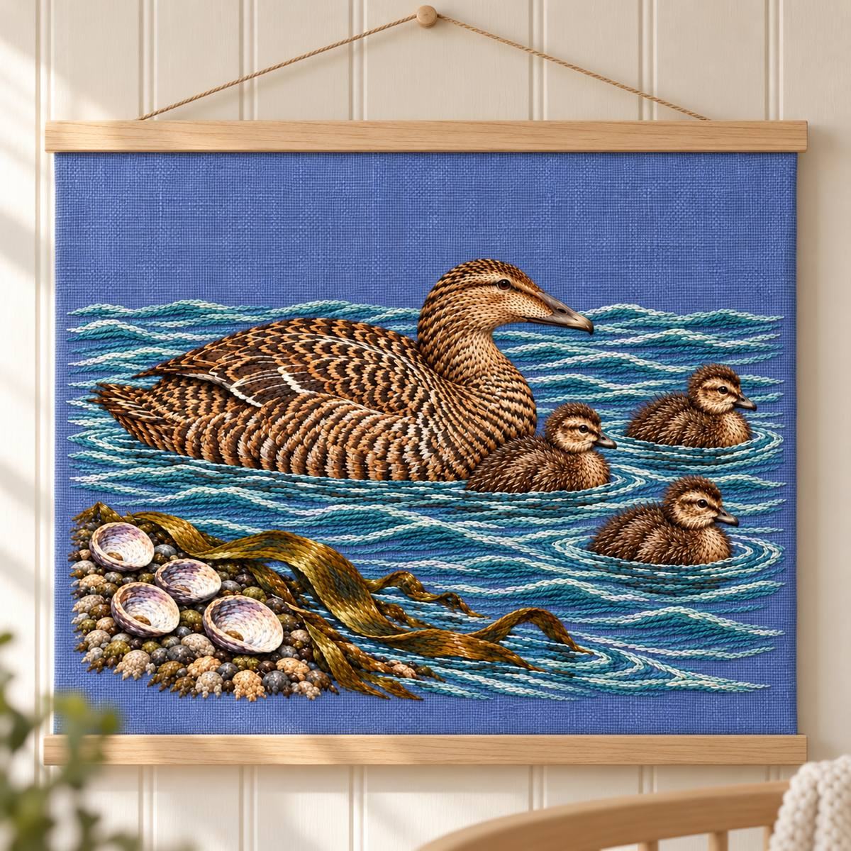 Eider and Chicks embroidery design in a digital mockup of lavender-blue linen heirloom panel suspended between slim pale wooden rails, framed tightly on nursery wall with soft side light, no lettering or surrounding bird decor. Placement inspiration for Study 34.