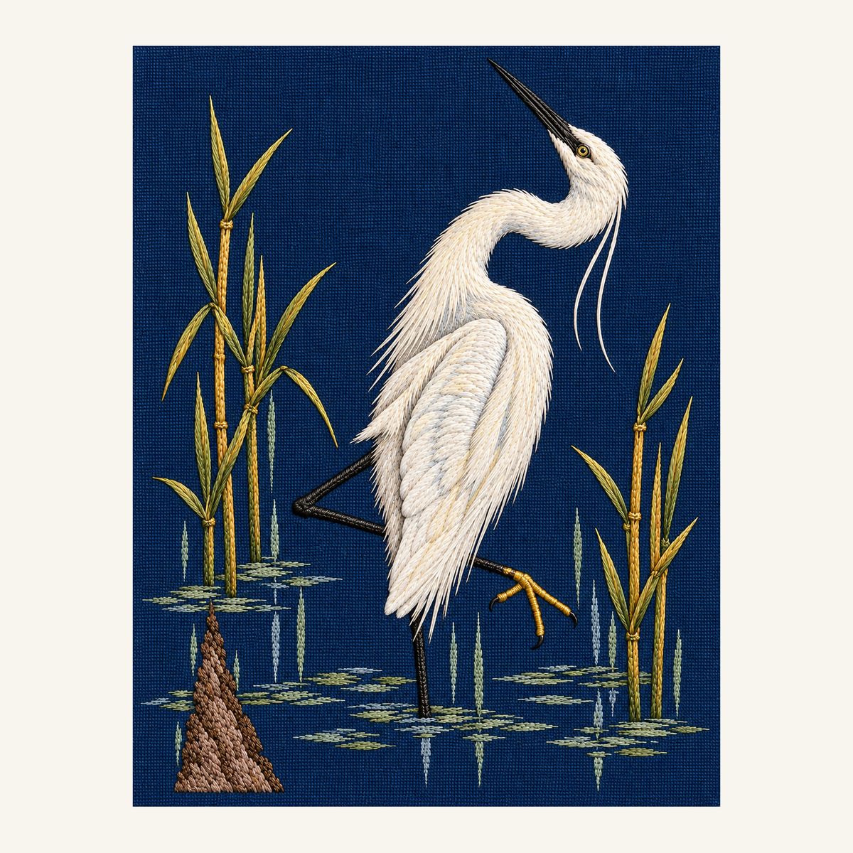 Digital embroidery reference showing an upright egret among sparse reeds on deep blue linen, portrait composition.