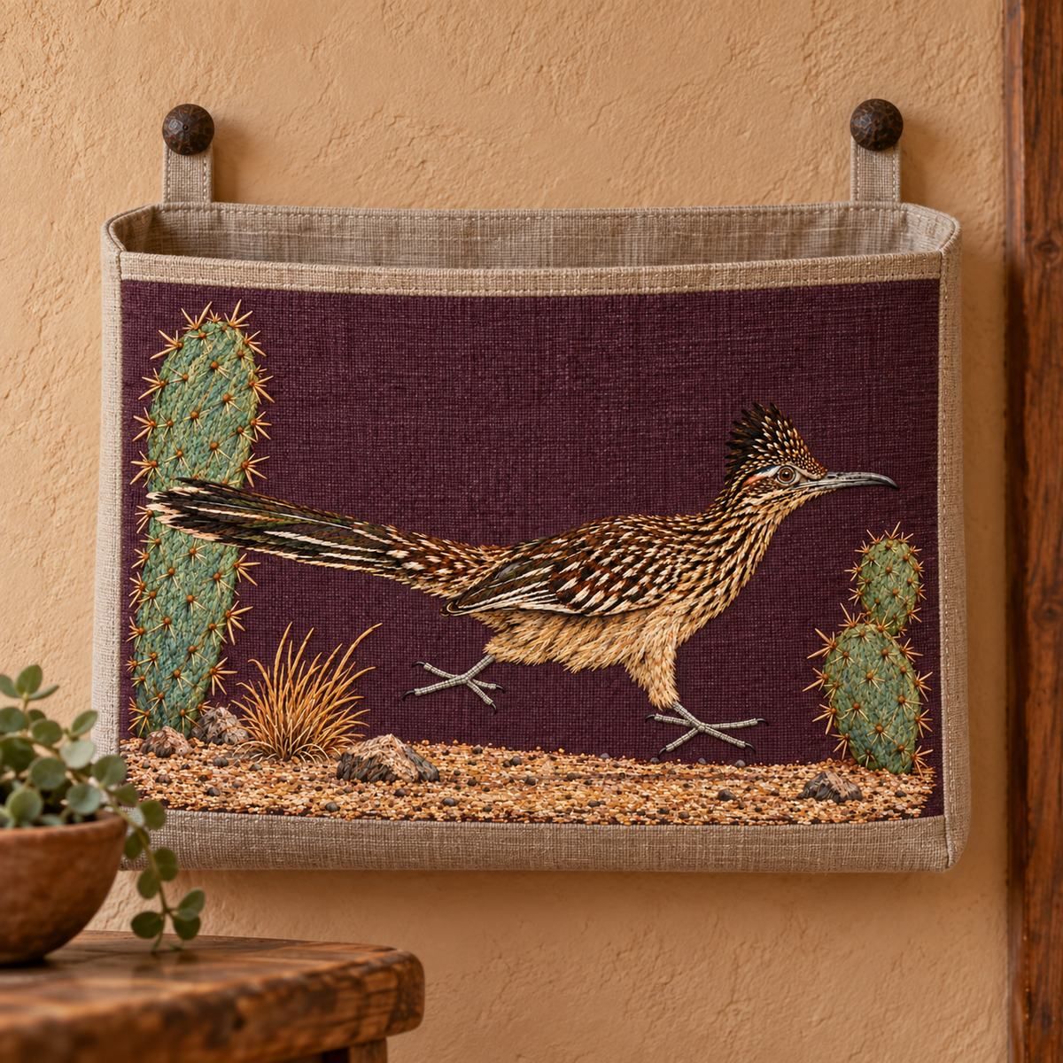 Roadrunner embroidery design in a digital mockup of Small wall-mounted mail organizer with one broad flat linen pocket . Landscape embroidered pocket front, edges plain, no letters covering image, adobe hallway. Placement inspiration for Study 47.