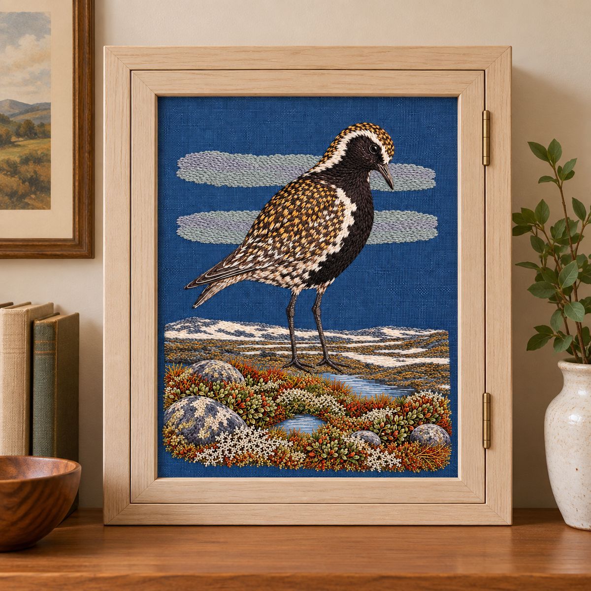 Golden Plover embroidery design in a digital mockup of A portrait textile inset into a bleached-wood medicine cabinet door in a dry reading room, not bathroom; exact complete scene. Placement inspiration for Study 68.