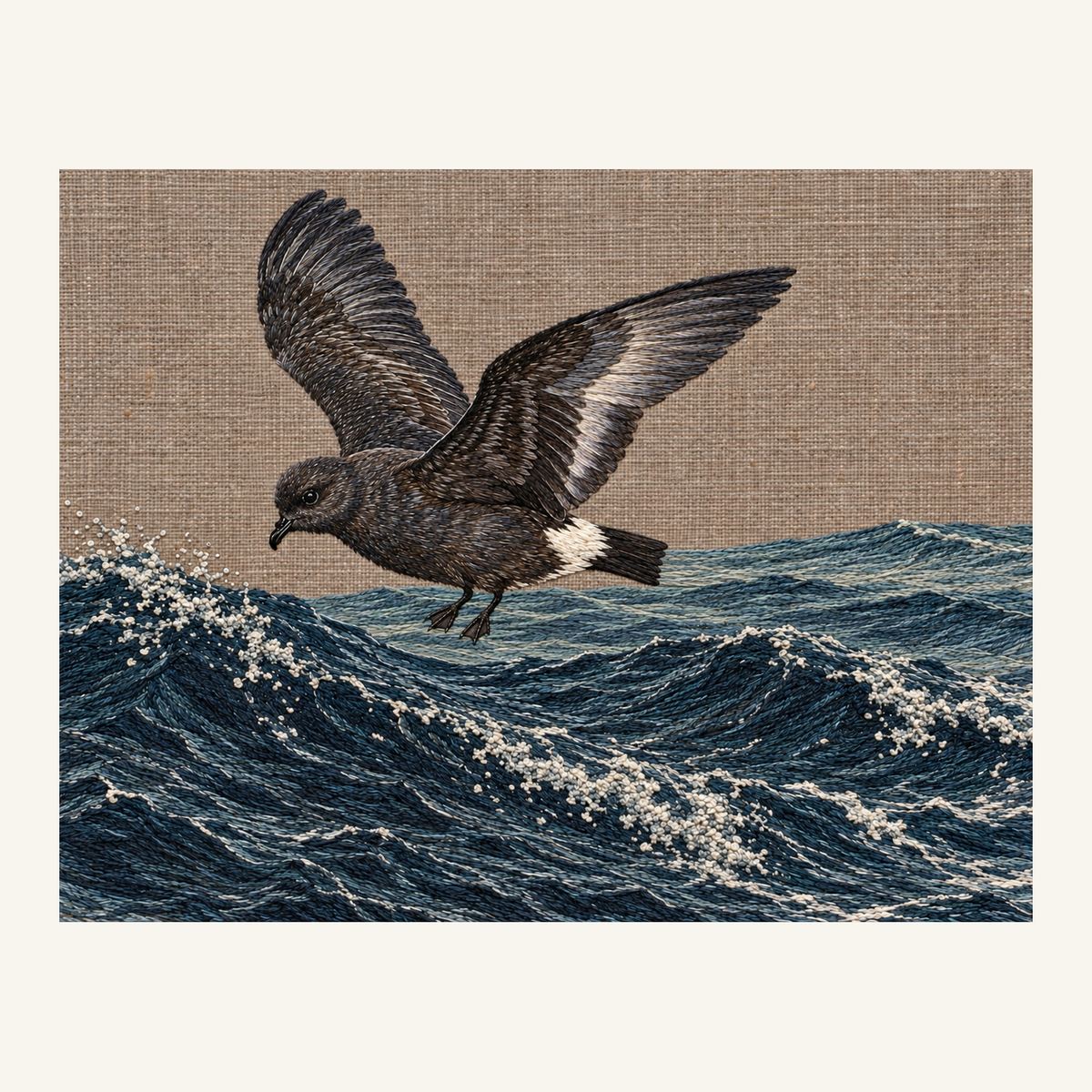 Digital embroidery reference showing a storm-petrel hovering above broken waves on muted warm copper-grey linen, landscape composition.