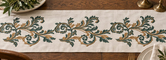 Two-color seamless acanthus machine embroidery repeated horizontally across a linen table runner with even spacing