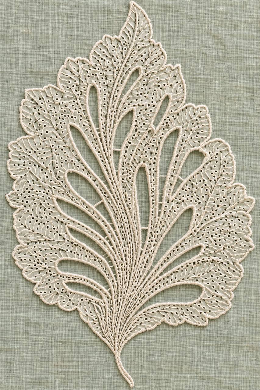 Digital embroidery visualization: ivory cotton cutwork leaf with branching openwork channels and tiny eyelets on pale celadon linen.