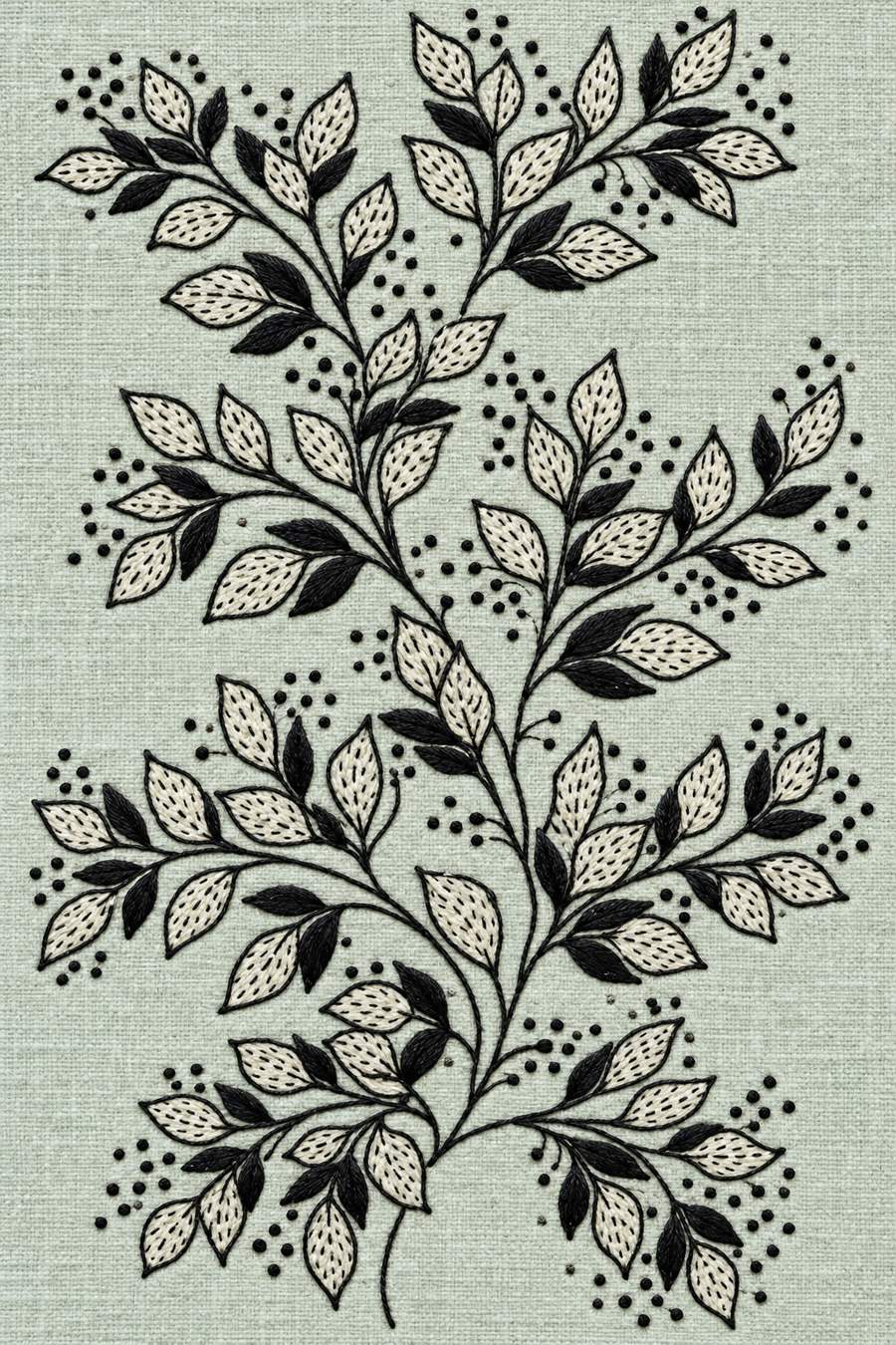 Hand embroidery of one tall branching leafy spray with alternating open dotted leaves and solid charcoal leaves, with original scattered seed-dot groups in charcoal-black and ivory cotton on pale muted celadon linen.