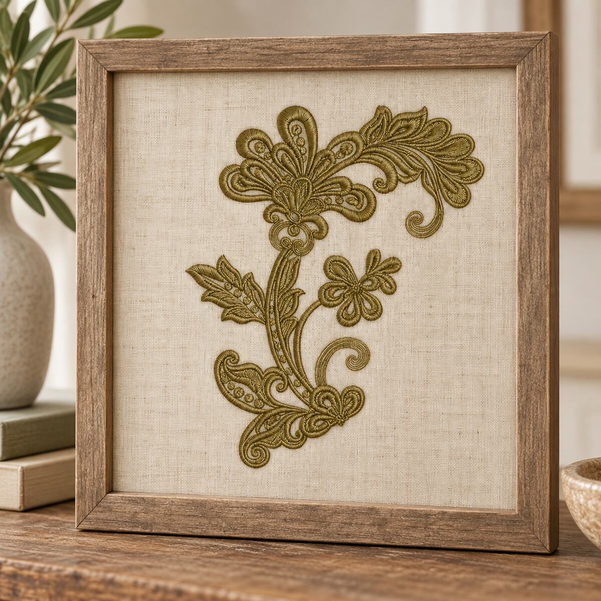 Single-color ornamental floral scroll corner machine embroidery displayed on a framed linen panel