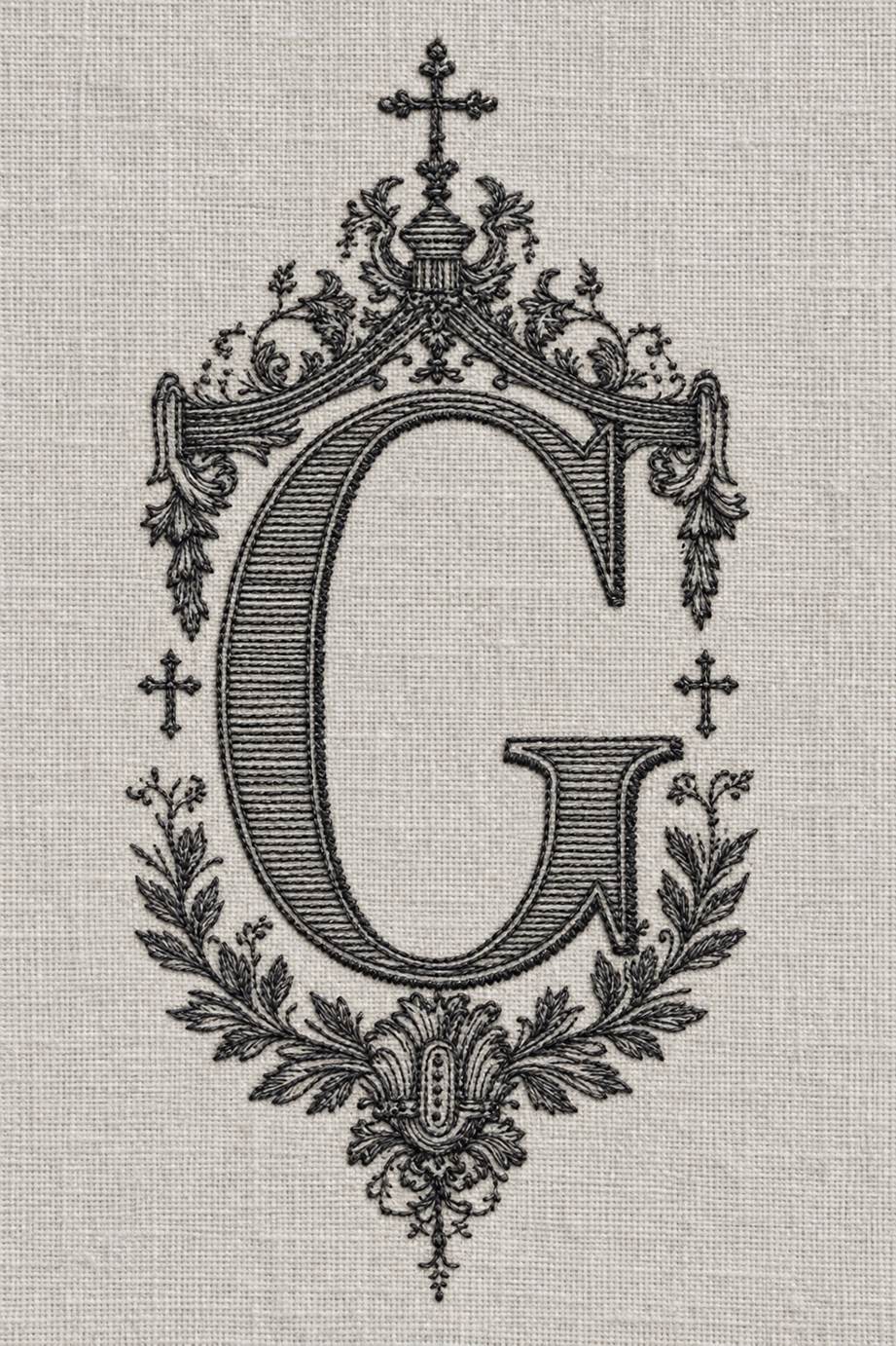 Fine cotton embroidery of ornate g monogram with crosses on pale stone grey linen.