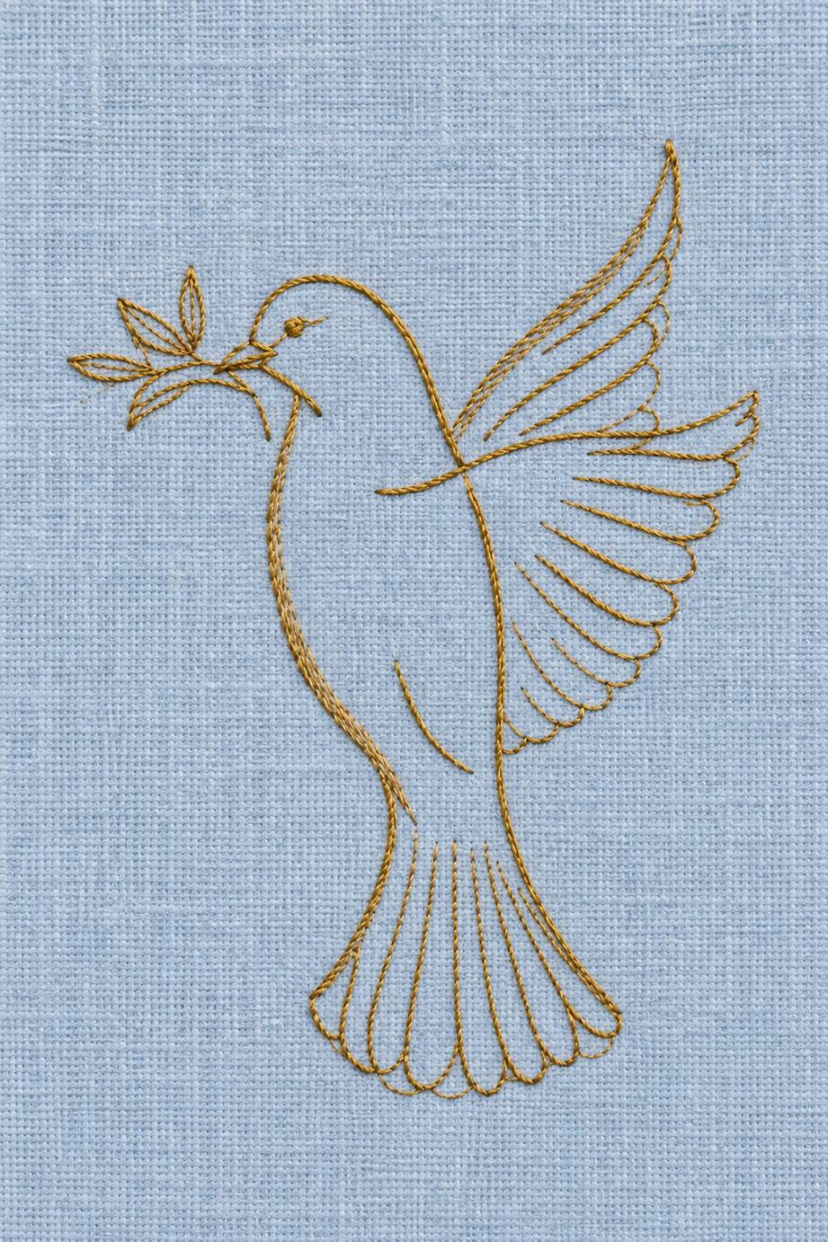 Fine cotton embroidery of outline dove with olive branch on powder blue linen.