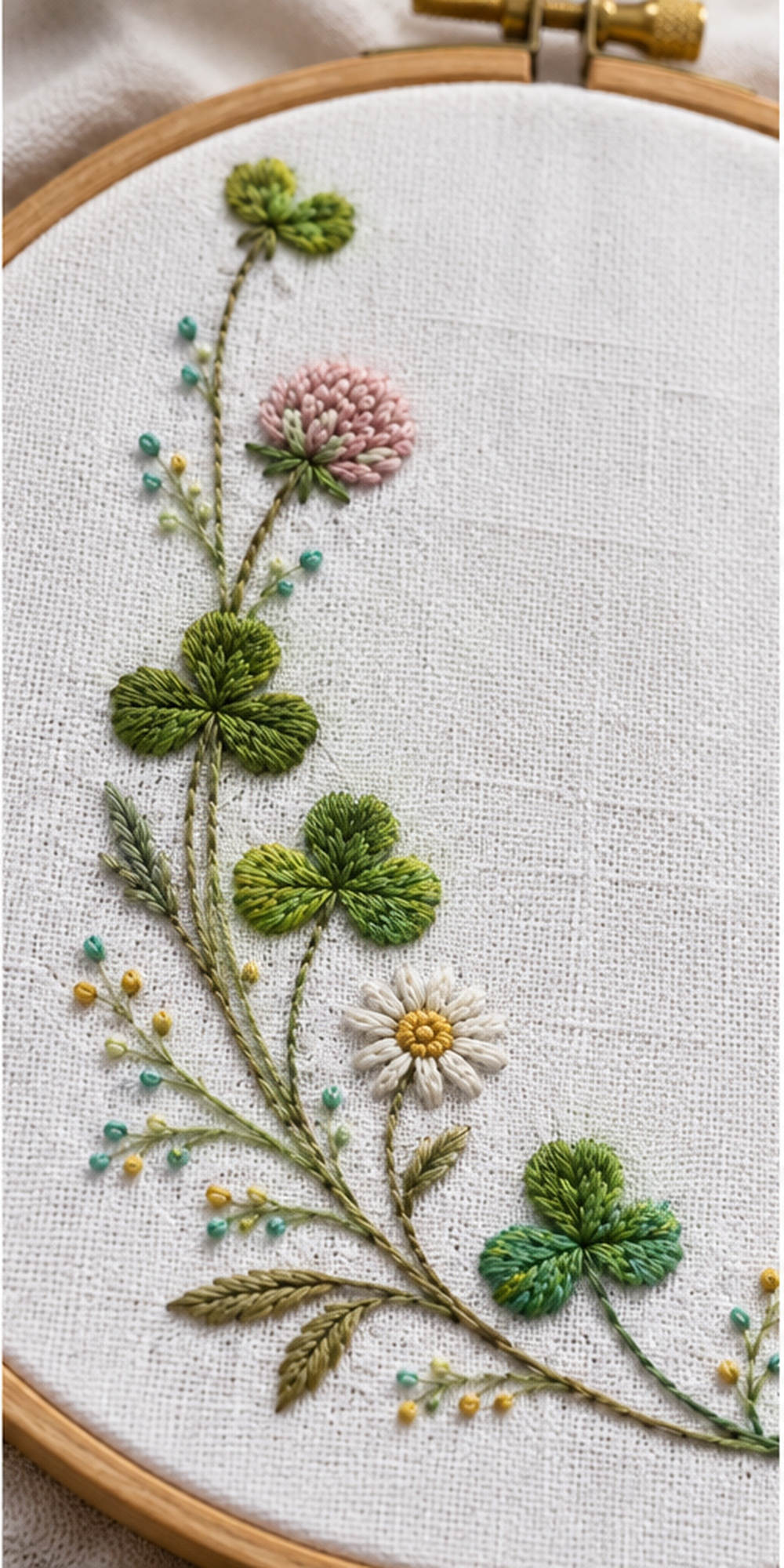 Clover textile close view mockup featuring the Clover Napkin Corner hand embroidery design. Clover grows along an L-shaped lower-left corner, with an unfilled circle in the upper-right field.