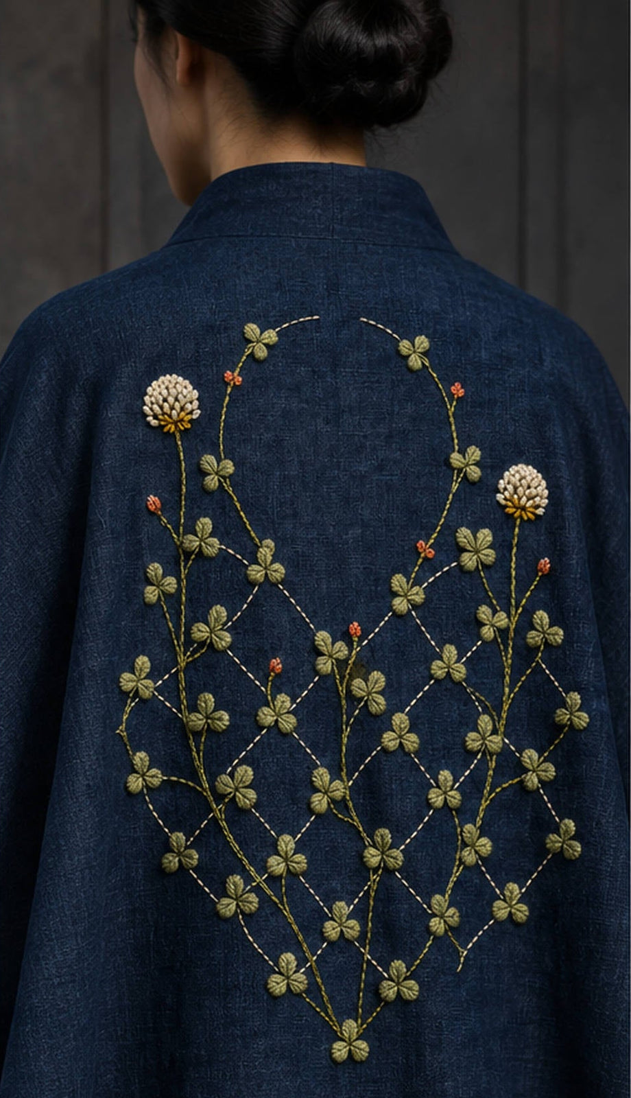 Navy linen shirt mockup featuring the Diamond Clover Lattice hand embroidery design. Clover vines climb through an incomplete diamond lattice on indigo linen.