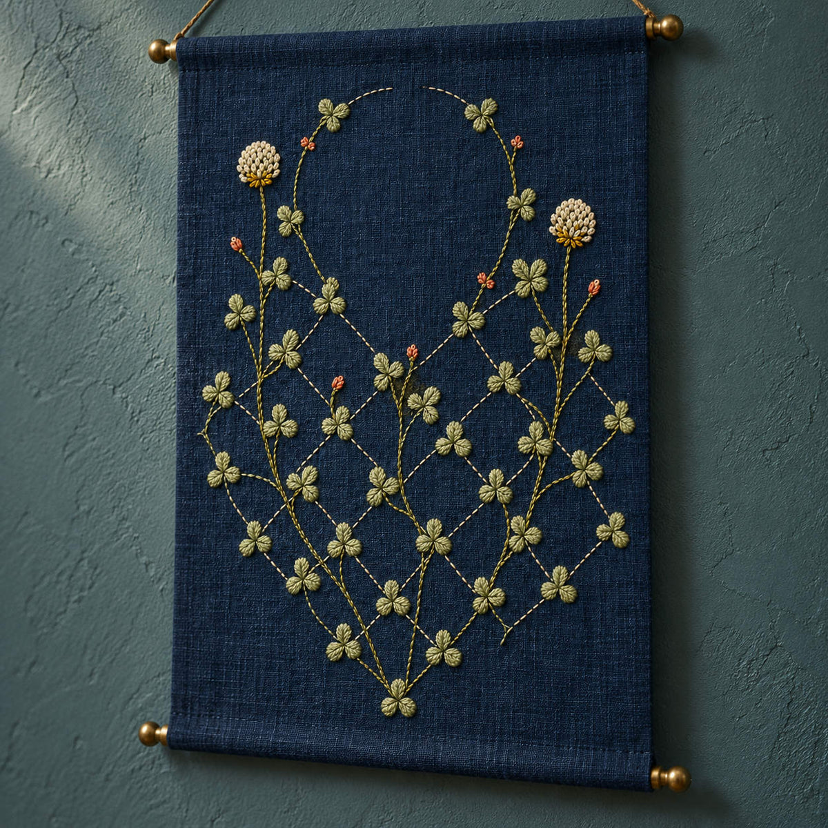 Close view of the clover lattice mockup featuring the Diamond Clover Lattice hand embroidery design. Clover vines climb through an incomplete diamond lattice on indigo linen.