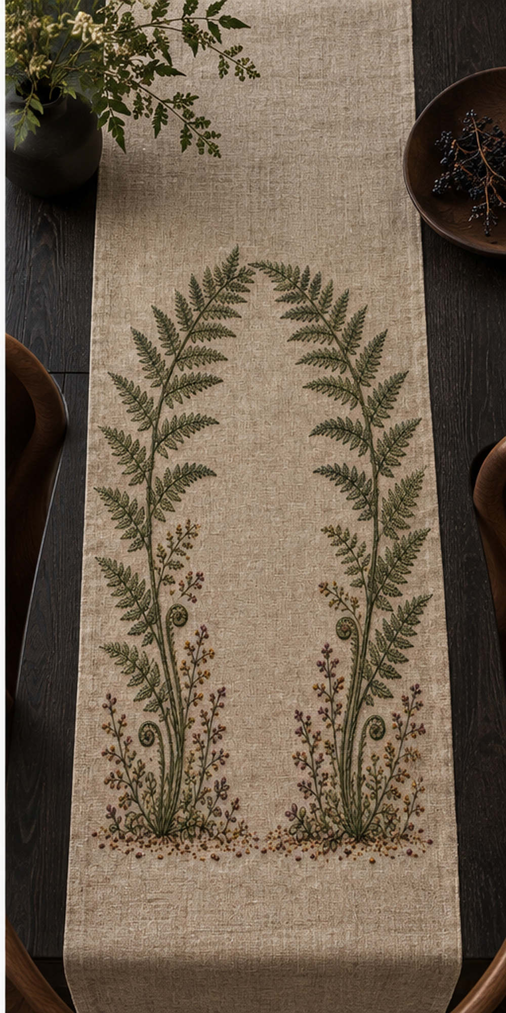 Linen notebook cover mockup featuring the Fern Arch and Quiet Ground hand embroidery design. Layered fern stems form an arch above fiddleheads and woodland sprigs.
