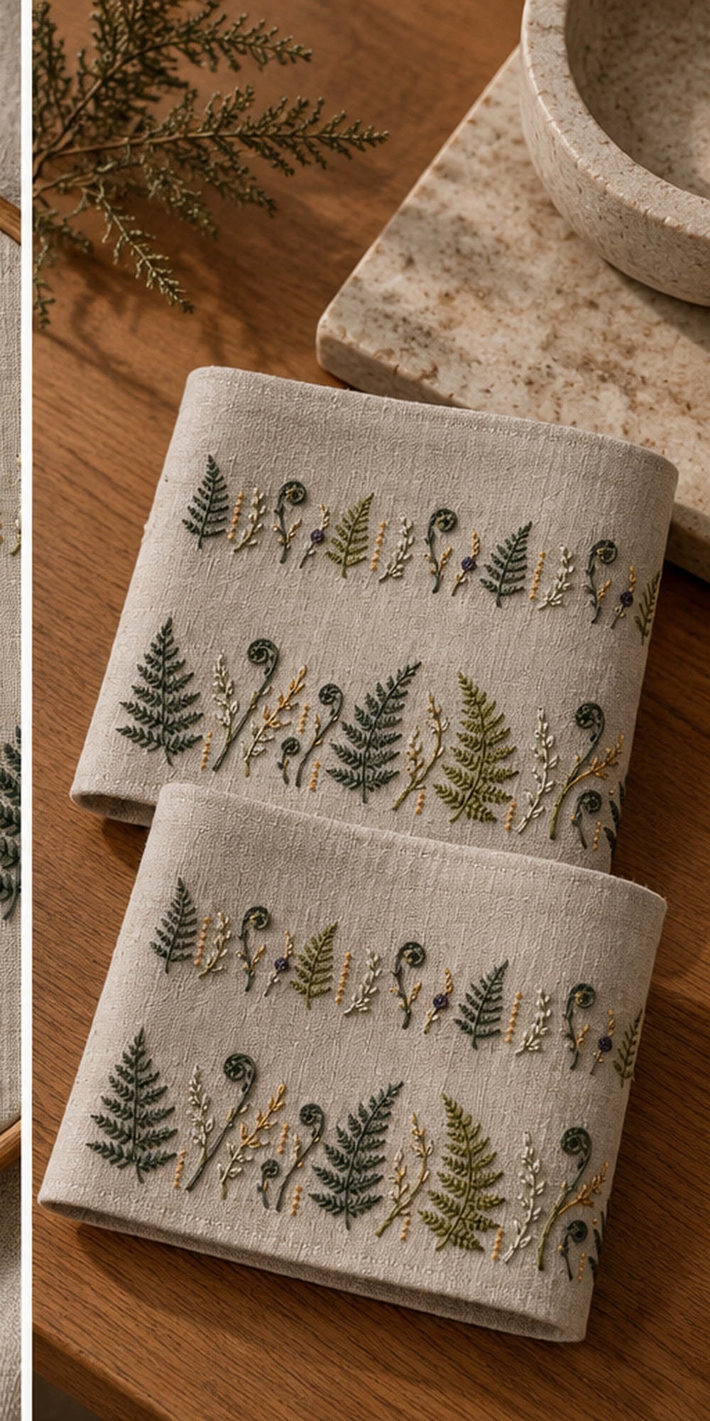 Fabric tool roll mockup featuring the Fern Cuff Pair hand embroidery design. Two horizontal bands alternate fern fronds, fiddleheads and fine seed stems.
