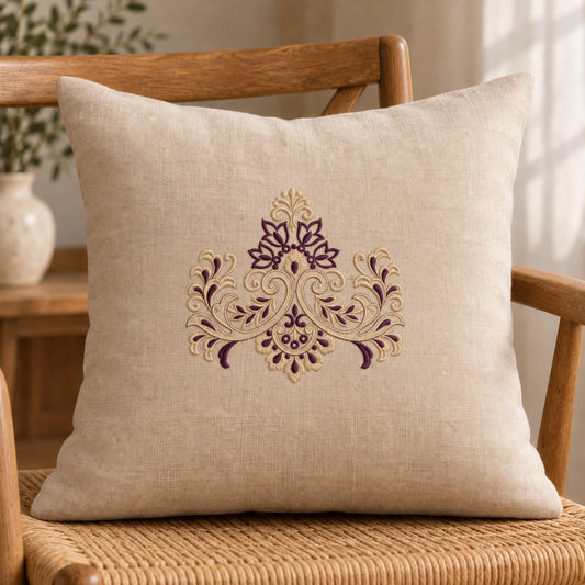 Symmetrical Floral Damask Crest embroidered in champagne and aubergine on a linen cushion, showing the complete two-color motif.