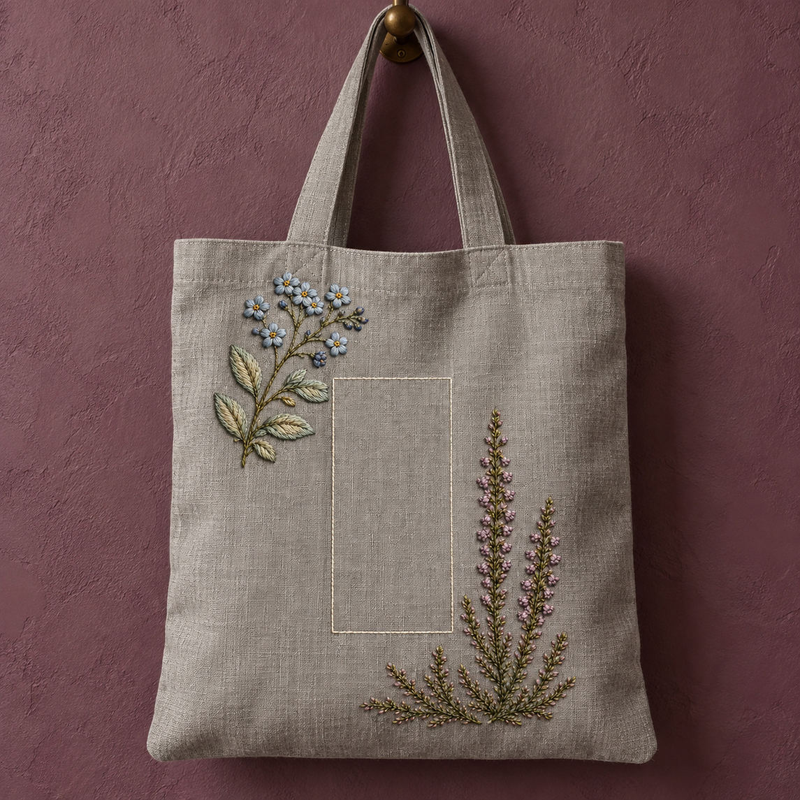 Linen tote bag mockup featuring the Forget-Me-Not and Heather hand embroidery design. Blue forget-me-nots cross a mauve heather branch in this small-flower embroidery pattern.