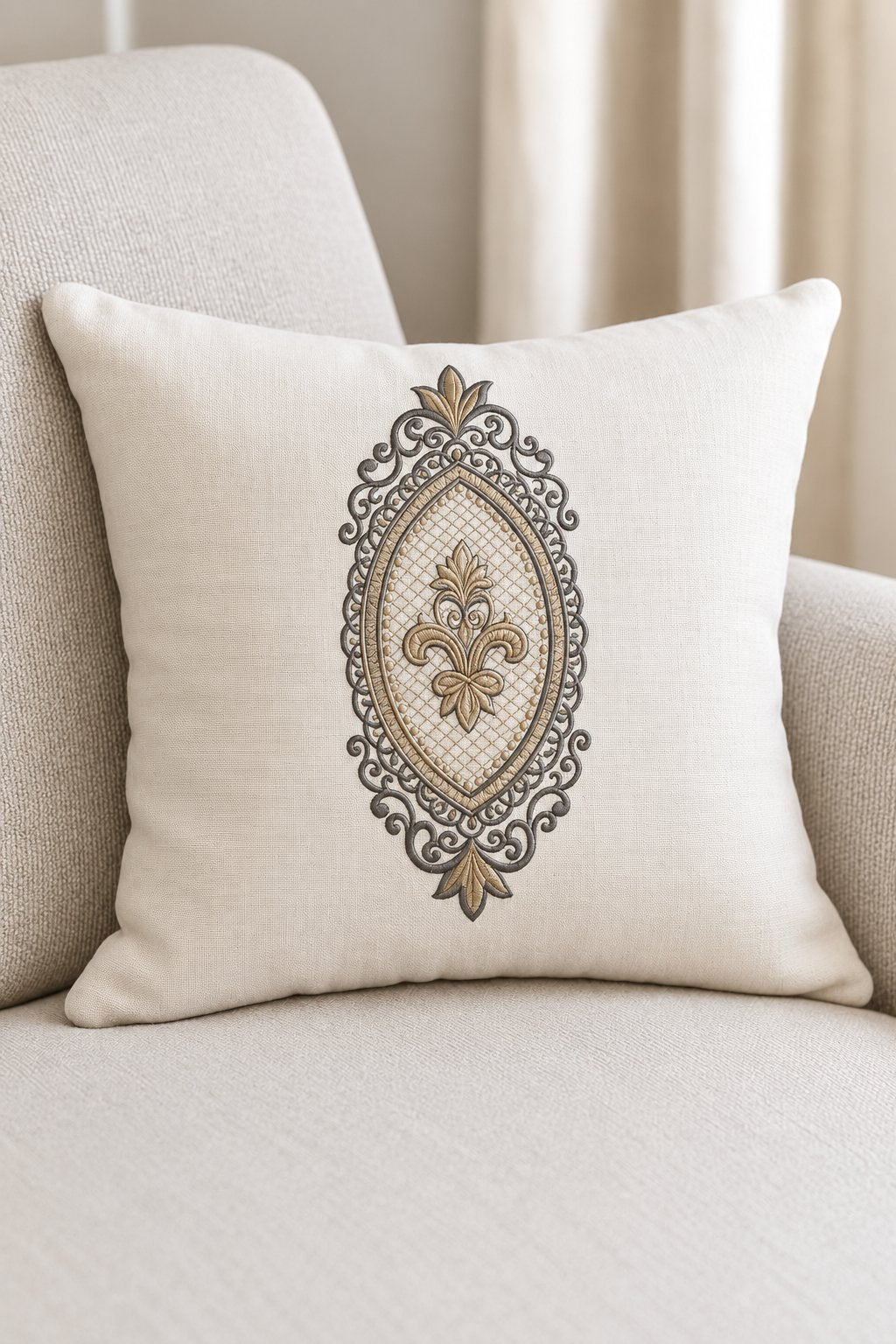 Photorealistic oval fleur filigree frame machine embroidery in graphite and champagne thread on a oversized linen cushion, shown as one fabric-stitched motif