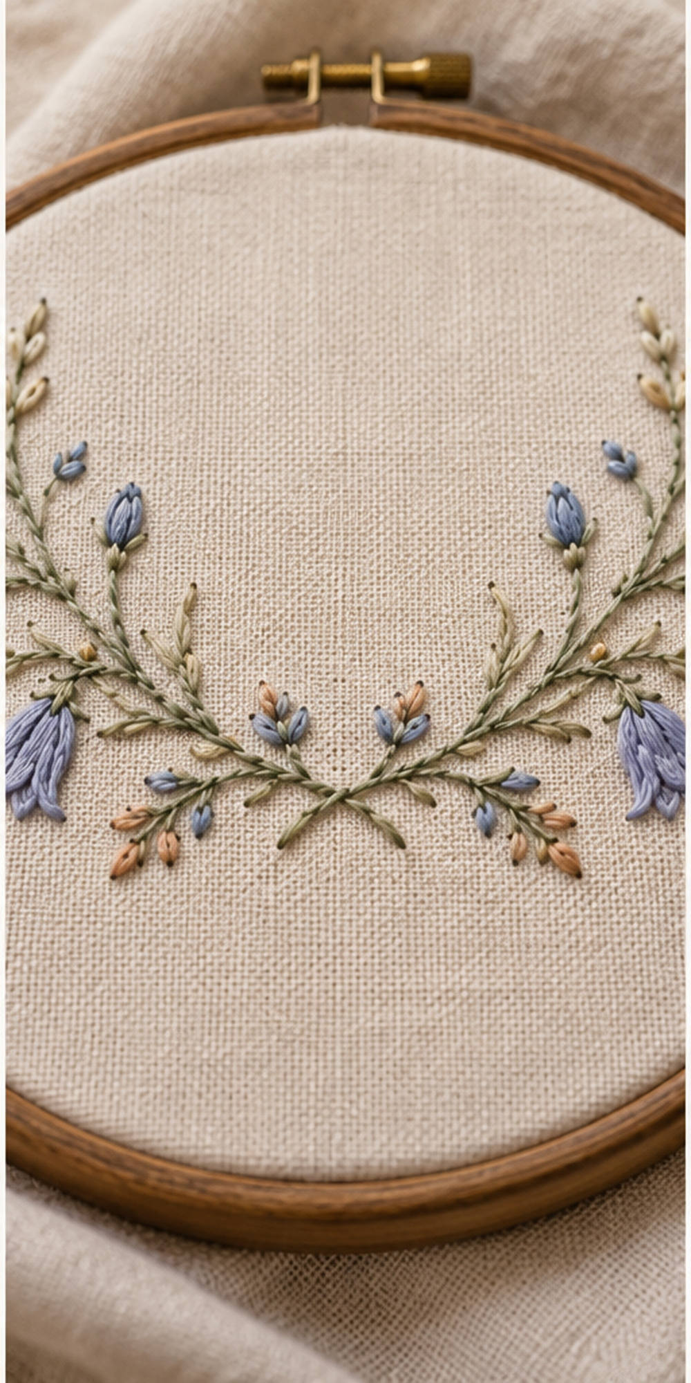 Floral textile flat lay mockup featuring the Harebell Collar Arc hand embroidery design. Blue harebells, buds and fine foliage follow a shallow collar arc.