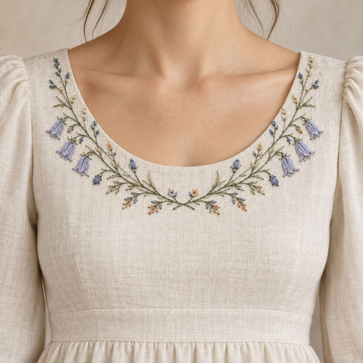Linen blouse neckline mockup featuring the Harebell Collar Arc hand embroidery design. Blue harebells, buds and fine foliage follow a shallow collar arc.