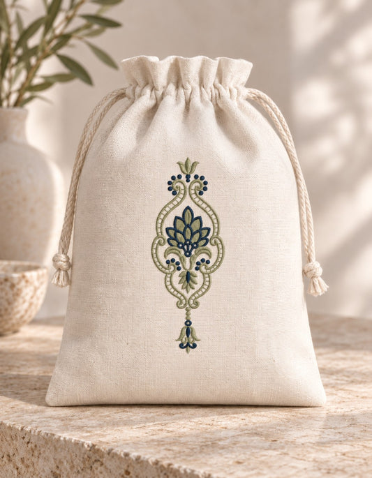Leaf Fan Scroll Pendant embroidered in smoky sage and ink blue on a linen drawstring pouch, showing the complete two-color motif.