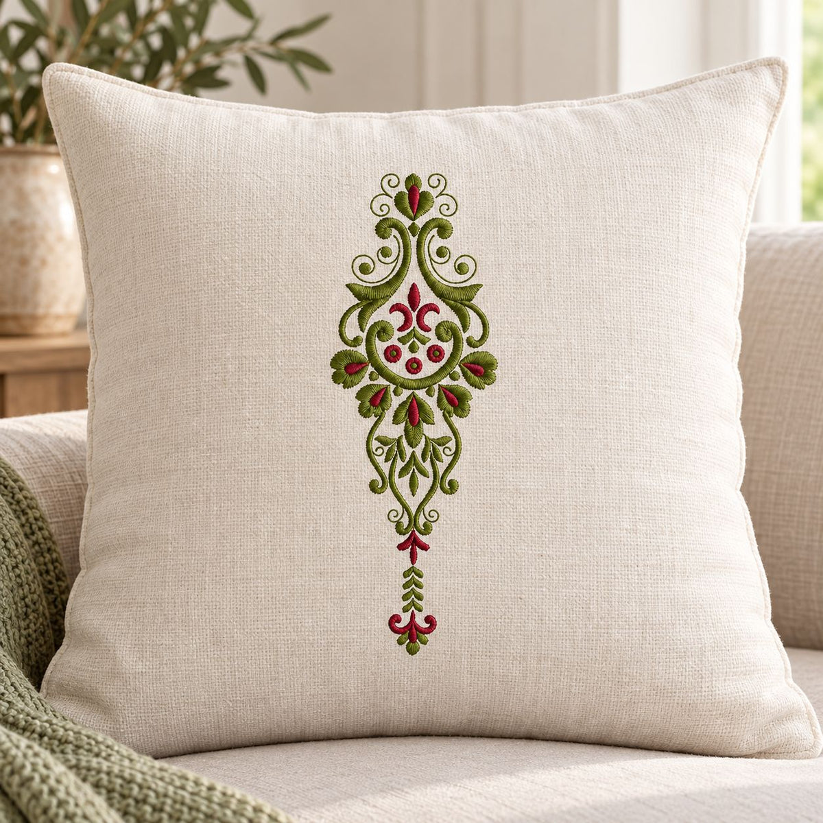 Photorealistic pendant floral scroll machine embroidery in deep olive and muted burgundy thread on a linen decorative cushion, shown as one fabric-stitched motif