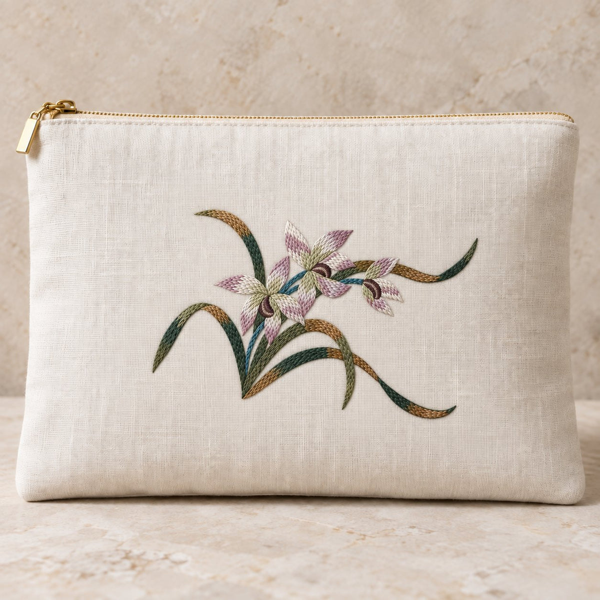 Ivory linen zip clutch embroidered with three mauve and parchment orchids, layered green leaves and dark flower centers.