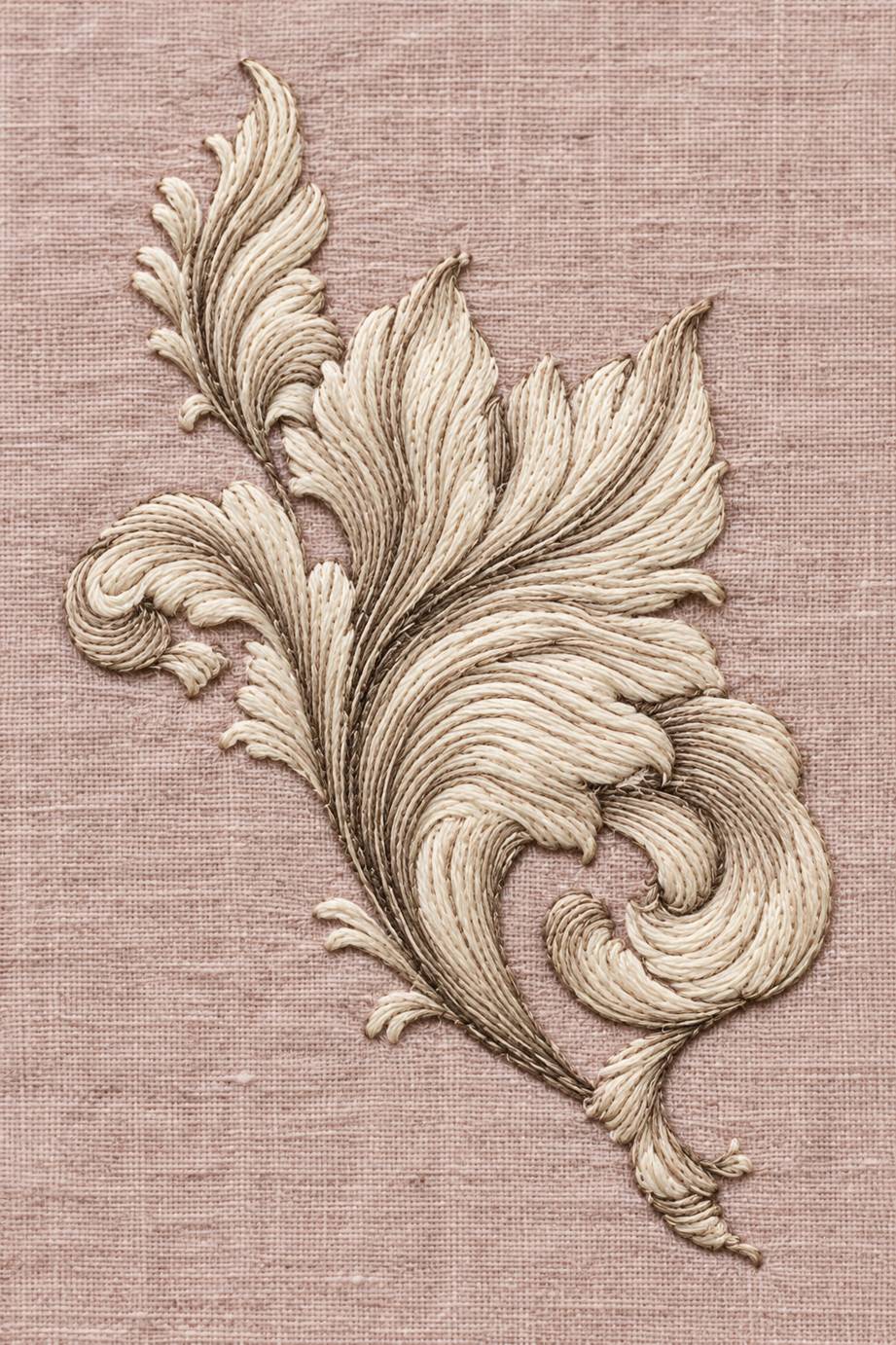Warm ivory cotton acanthus corner ornament with curled leaves embroidered on pale dusty rose linen.