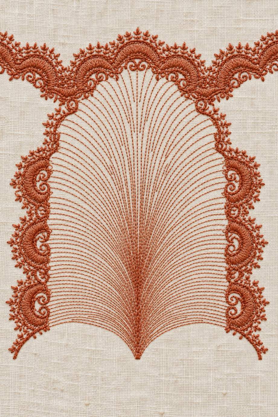 Muted terracotta cotton fan arch with delicate radiating stitch lines and leafy scalloped edging on warm ivory linen.