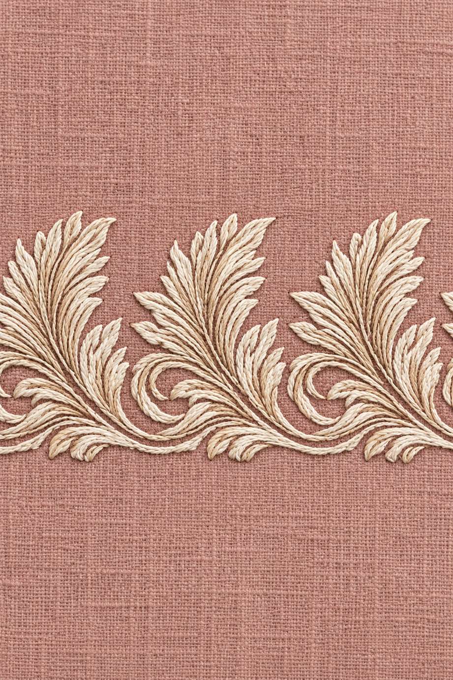 Fine ivory cotton repeating acanthus leaf border with curled stems embroidered on muted dusty rose linen.