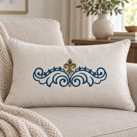 Two-color fleur-de-lis scroll machine embroidery centered on an ivory linen lumbar cushion