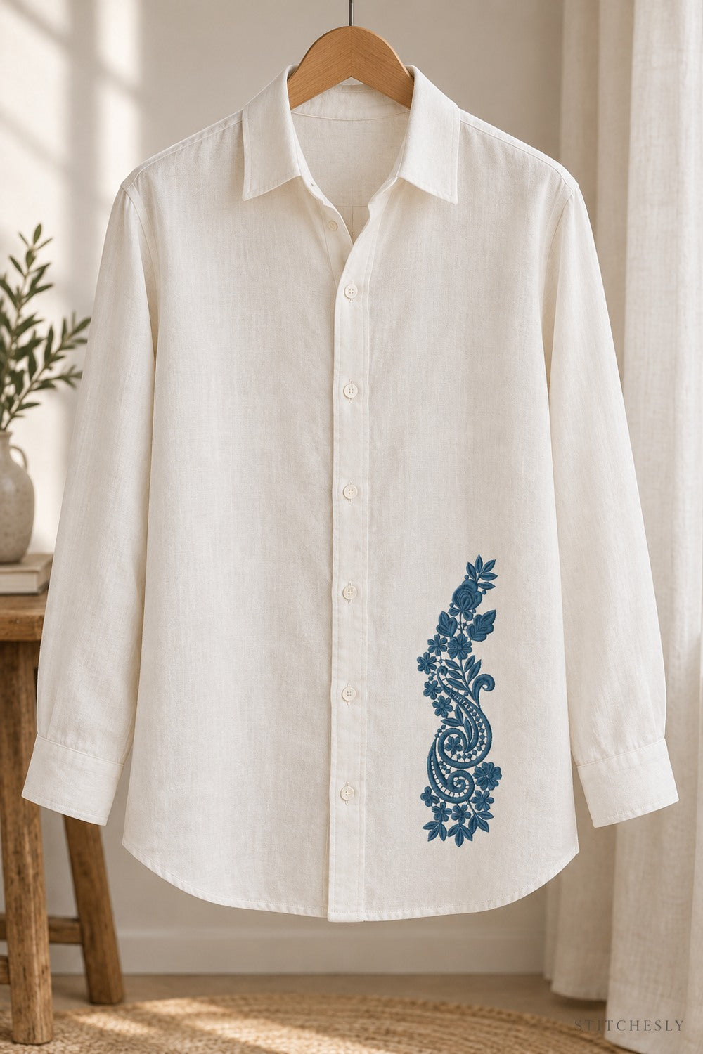Generated usage mockup of a linen overshirt with the rose and twin paisley spray machine embroidery motif in one deep muted petrol blue thread color.