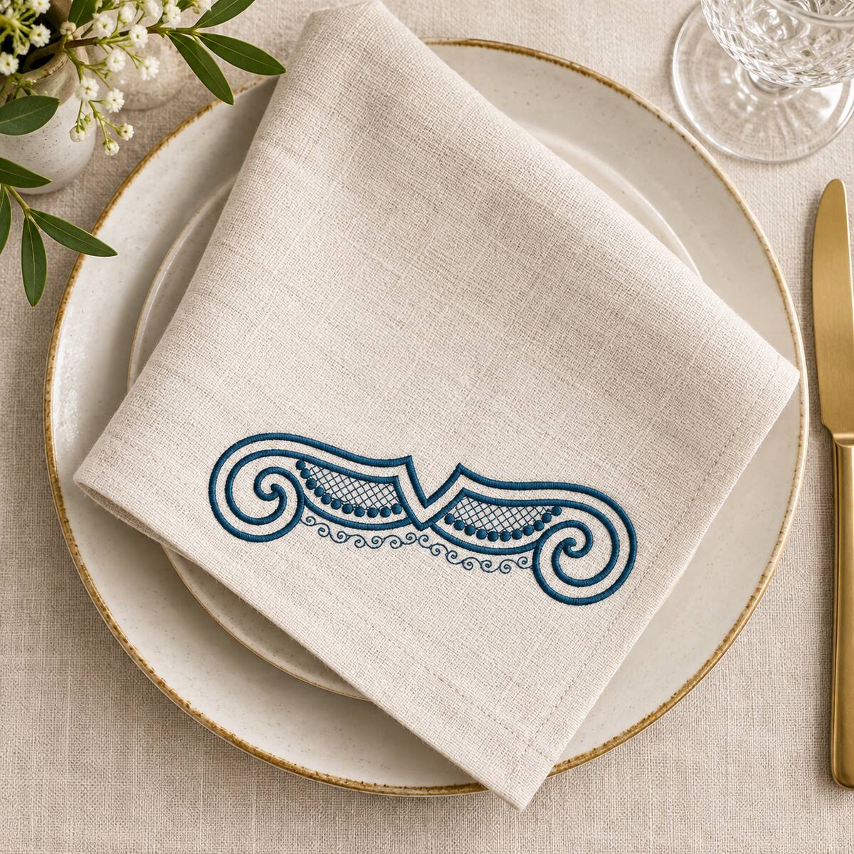 Single-color petrol shell scroll machine embroidery on a natural linen dining napkin