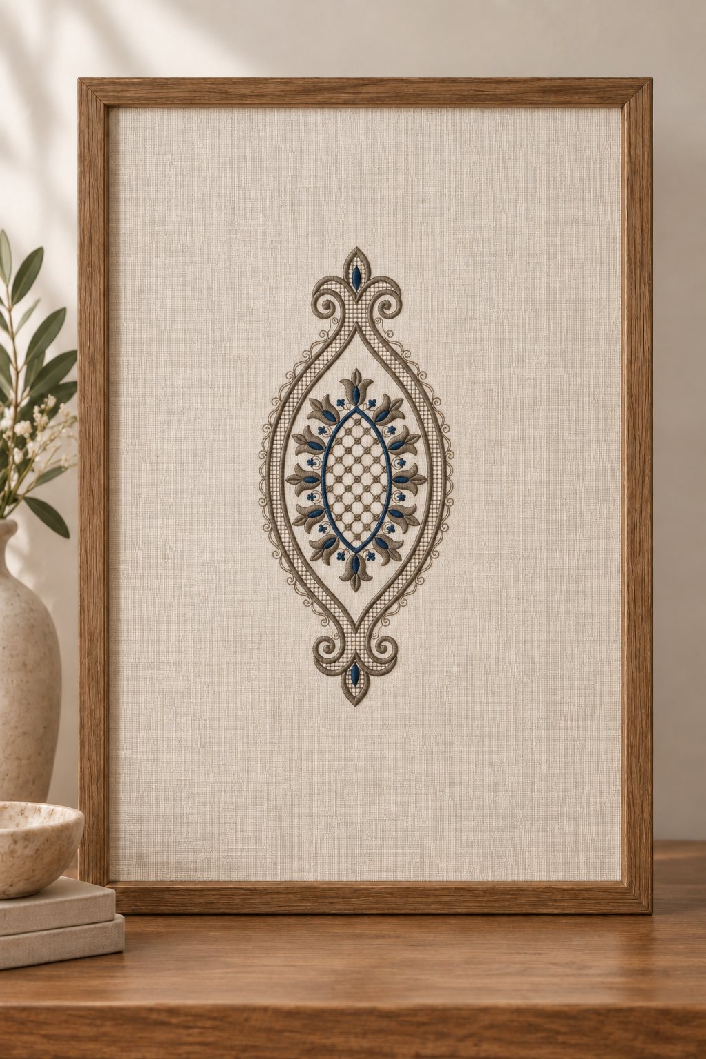Wooden frame holding ivory linen embroidered with a pewter and midnight blue tulip teardrop medallion.