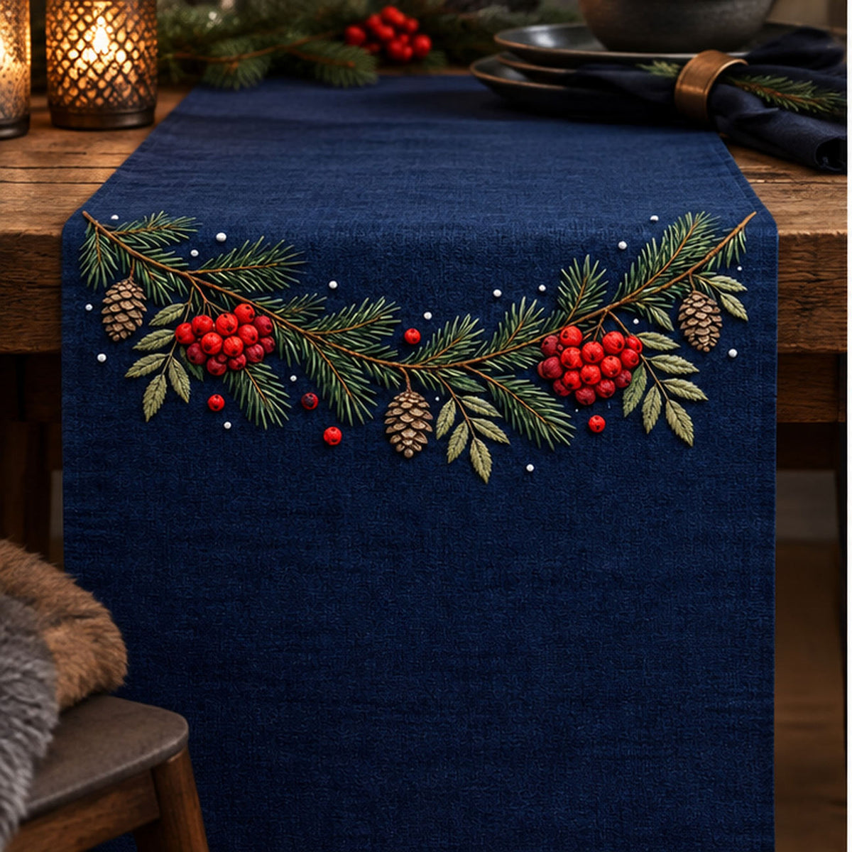 Navy hanging panel mockup featuring the Rowan and Pine Winter Garland hand embroidery design. Pine needles, rowan berries and cones follow a shallow upper curve with sparse snow-like dots nearby.