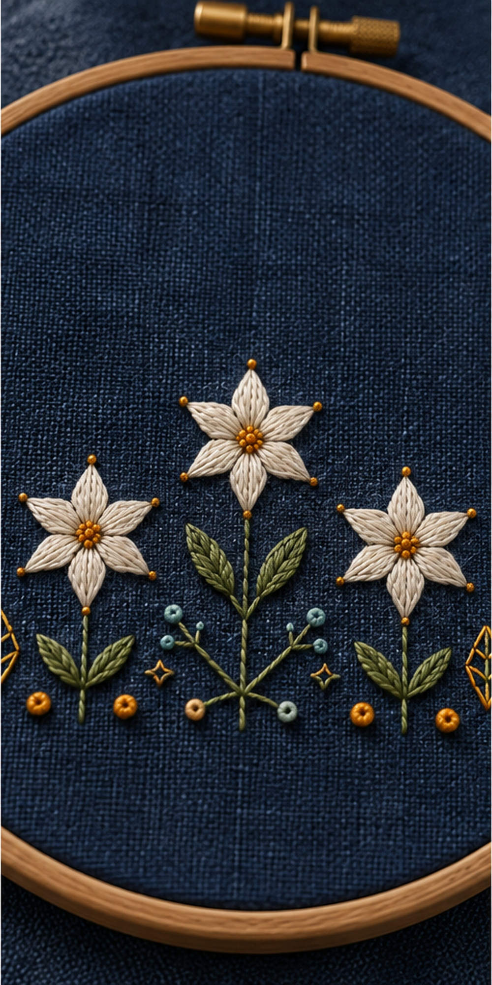 Embroidery hoop close view mockup featuring the Starflower Border Chain hand embroidery design. White starflowers form a low border on indigo, with a taller central bloom and small geometric ground marks.
