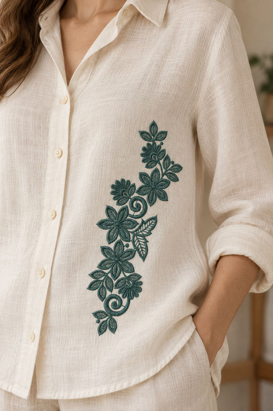 Linen shirt with a single deep muted teal green machine-embroidered star bloom and fan flower vine motif on natural ivory linen.