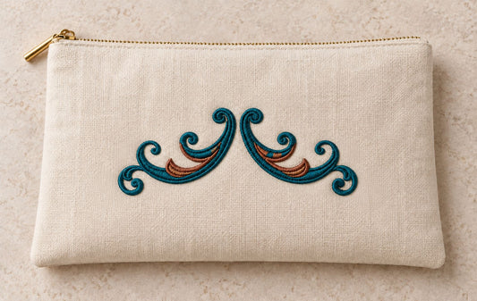Twin Curl Acanthus Swag embroidered in petrol teal and muted copper on a linen zipper clutch, showing the complete two-color motif.